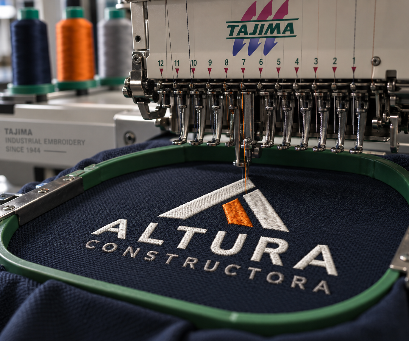 Bordado industrial del logotipo Altura Constructora en máquina Tajima de 12 cabezas