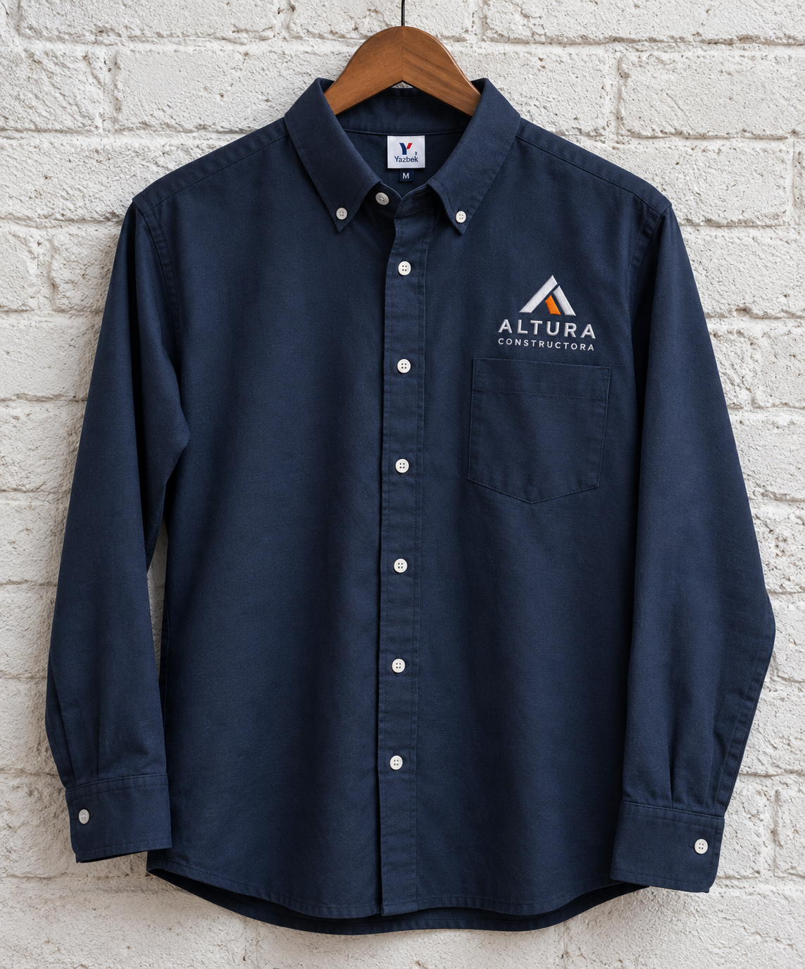 Camisa azul marino con logotipo Altura Constructora bordado en hilo blanco y naranja
