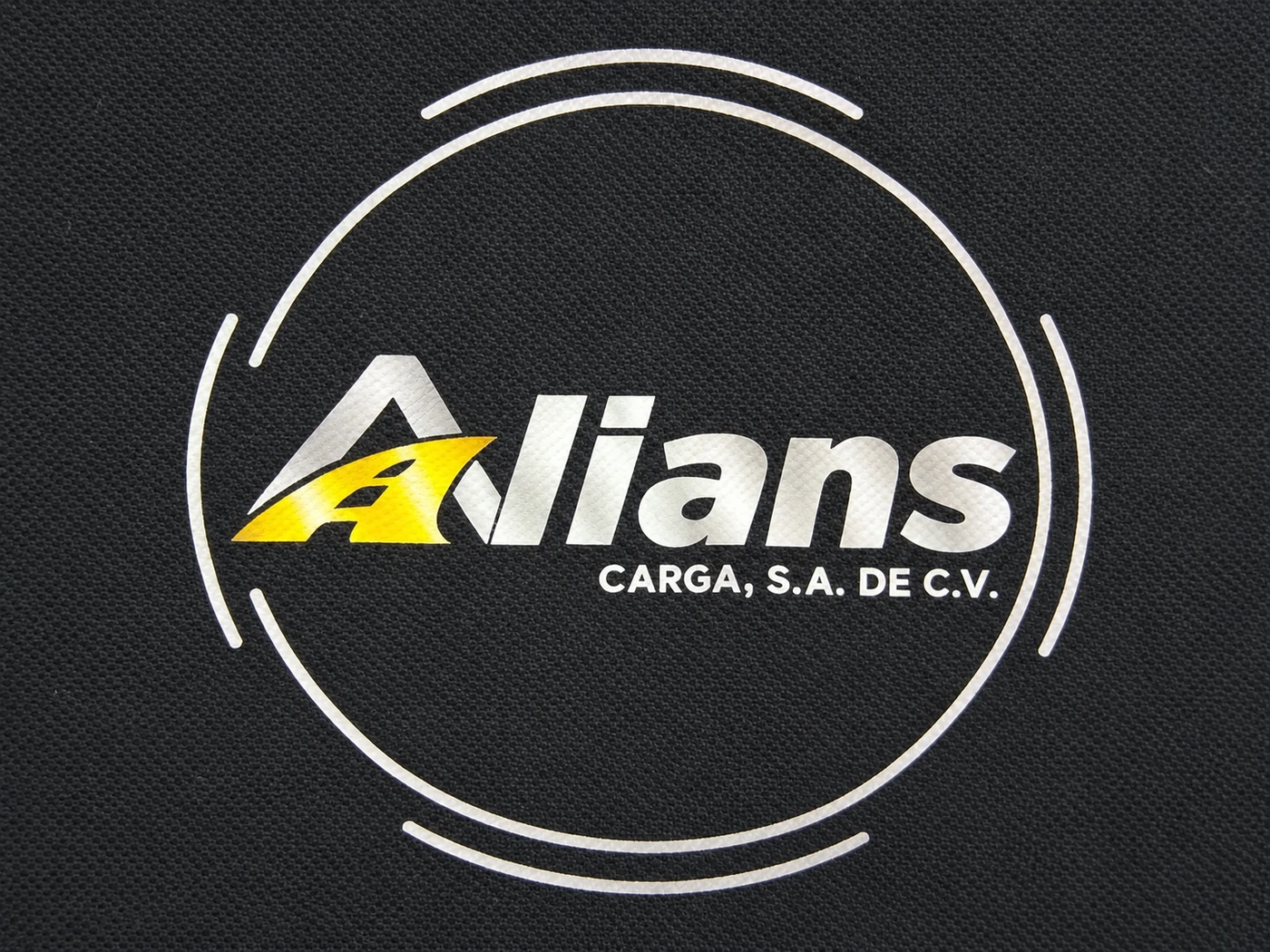 Detalle real del logo Alians Carga aplicado con DTF sobre polo marino